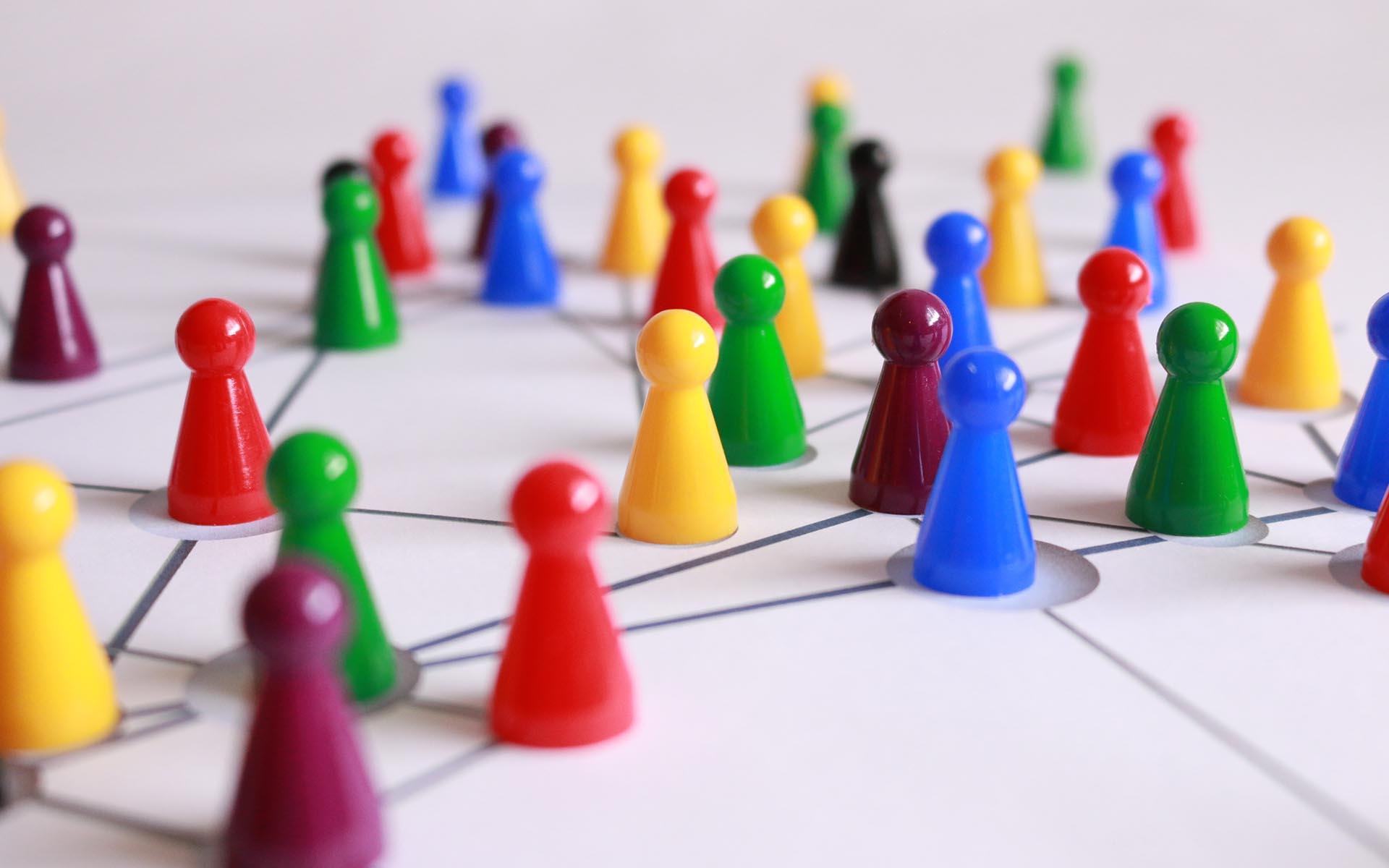 multicolored game pieces connected on a lined surface